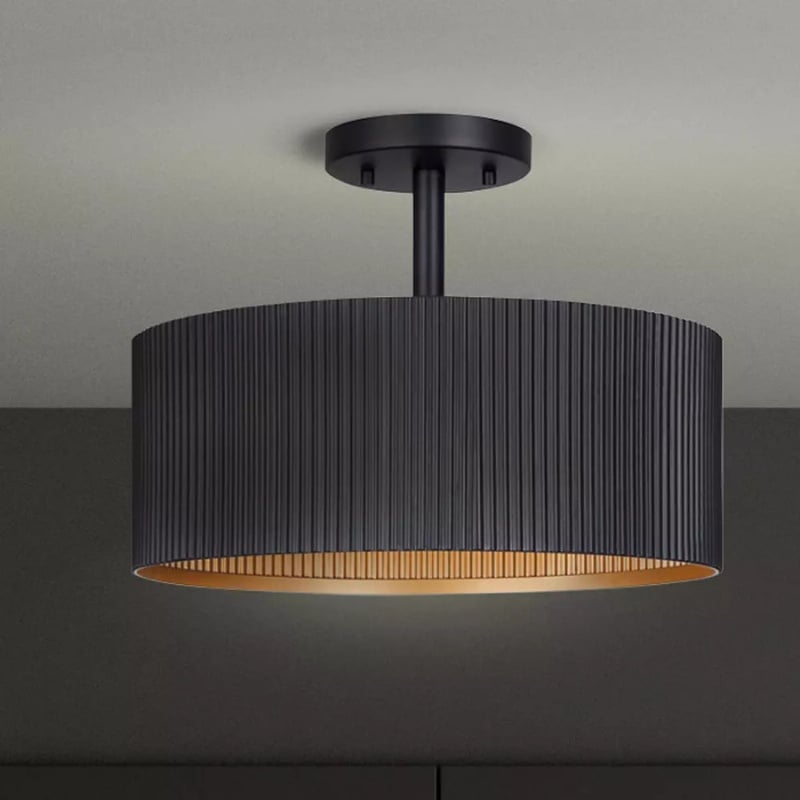Modern black ceiling light fixture with a ribbed design and warm gold interior, ideal for contemporary interiors.
