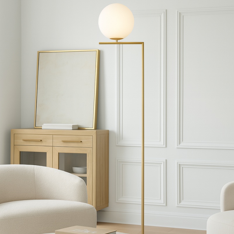 Modern floor lamp with a round white globe and gold frame, positioned next to a wooden sideboard and a cozy beige sofa in a stylish living room setting.